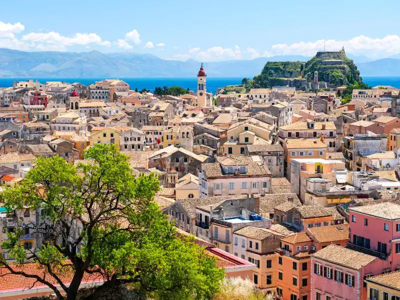 realistic photo of Kerkyra town during dayling with lush greens and houses