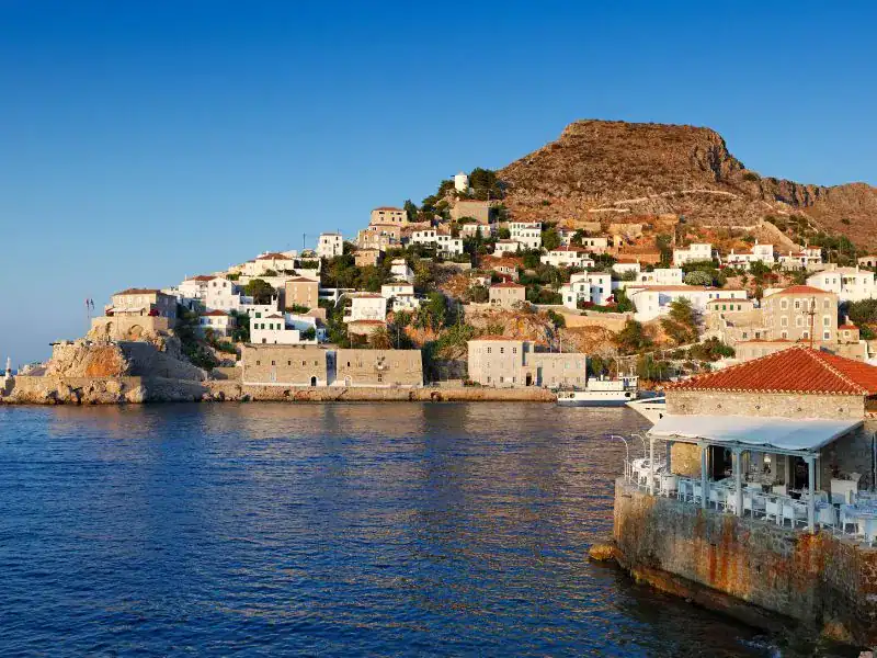 realistic photo of a town next to the sea featuring many small graphic greek island houses